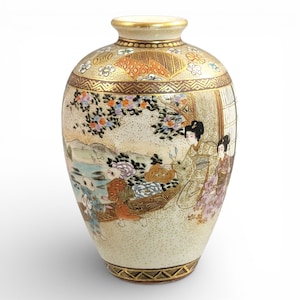 以下が含まれることがあります： クリーム色の陶器の花瓶。日本の風景が描かれ、金色の縁と底が特徴です。伝統的な衣装を着た人物が描かれた風景画があり、花柄や幾何学模様のデザインが施されています。エレガントな装飾品です。
