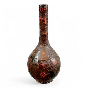 May include: A brown glass vase with a textured surface and floral designs in shades of orange, red, and green.
