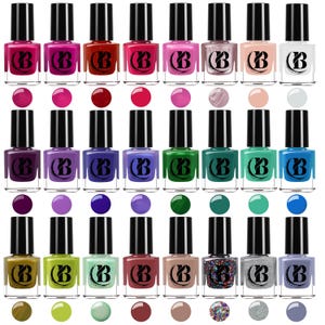 May include: A selection of nail polish bottles in a range of colours, such as pinks, reds, greens, blues, and neutral tones. Each bottle has a black cap and a colour swatch. The bottles are arranged in rows.