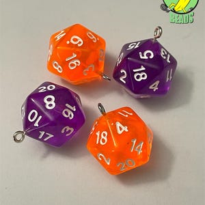 May include: Four polyhedral dice charms in orange and purple. Each die has white numbering and a silver loop for attaching to jewelry or other crafts. The dice are for tabletop games.