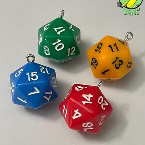 May include: Four colourful, twenty-sided dice with silver loops for hanging. The dice are green, yellow, blue, and red, with white numbers. These dice are likely for tabletop gaming.