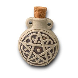 Peut inclure: Une petite bouteille en céramique avec un bouchon en liège. La bouteille est décorée d'un motif de nœud celtique brun et d'une étoile à cinq branches.