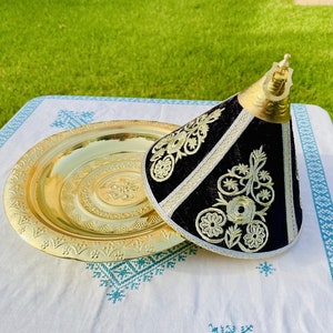 May include: A gold metal serving tray with a decorative embossed design and a black velvet cone-shaped lid with gold embroidery.