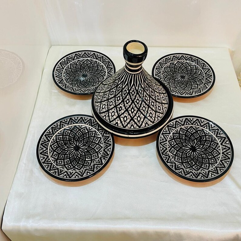 May include: A set of five black and white ceramic dishes with intricate geometric patterns. The set includes a large, domed dish and four smaller plates.
