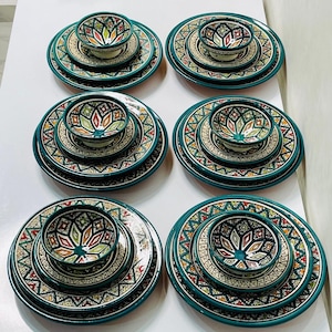 Op de afbeelding: Set van zes keramische dinerborden met bijpassende kommen. De borden en kommen hebben een geometrisch patroon in groen, wit en oranje.