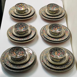 Può includere: Set di sei piatti in ceramica con intricati disegni geometrici in tonalità di blu, verde, rosso e bianco. Ogni piatto presenta una ciotola più piccola con un design simile.