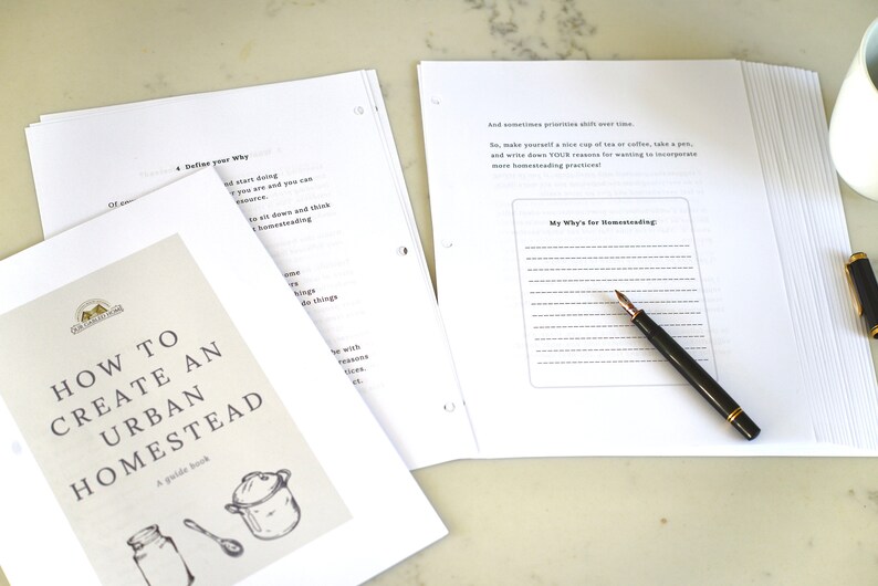 May include: A white guide book titled "How to Create an Urban Homestead" with a drawing of a pot, a jar, and a spoon. The book is open to a page with the title "My Why's for Homesteading" and a lined space for writing.