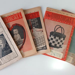 May include: Five vintage copies of "The Workbasket" magazine, a craft and home magazine. The covers feature a crocheted doily, a baby, a crocheted tablecloth, a crocheted bag, and a woman wearing a purple sweater.