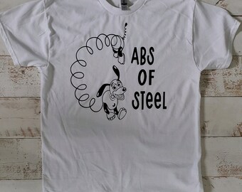 Peut inclure: T-shirt blanc avec un dessin de chien de dessin animé noir et les mots "ABS OF STEEL". Le chien est représenté avec un fil téléphonique. Le design est centré sur le t-shirt.
