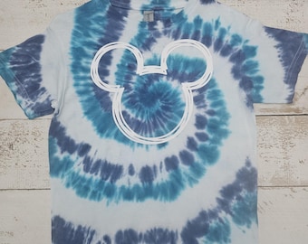 Peut inclure: Un t-shirt bleu et blanc tie-dye avec un contour blanc de la tête de Mickey Mouse.