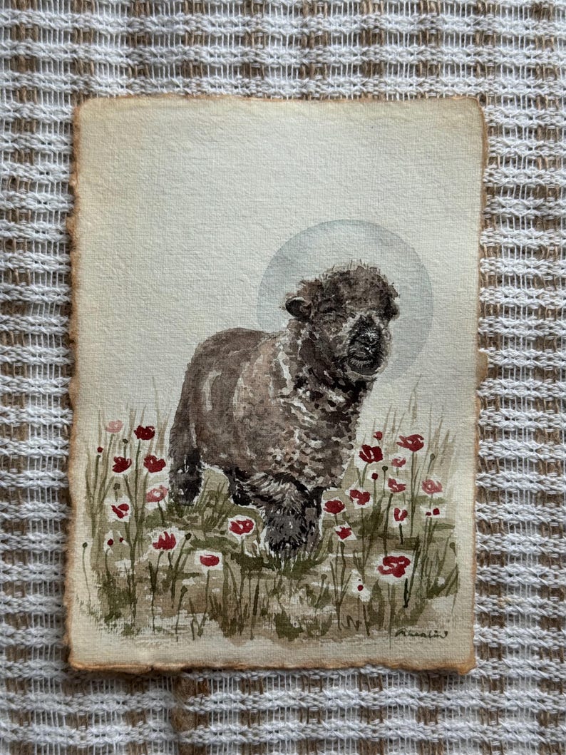 以下が含まれることがあります： 赤と白の花が咲く野原に立つ茶色の羊の絵。羊の頭の後ろには薄い灰色の光輪があります。このアートワークは、粗く破れた縁のある紙に描かれています。