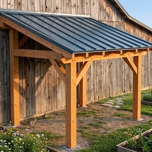 May include: A lean-to structure featuring a dark grey metal roof supported by a natural light brown wooden frame with vertical posts and diagonal support beams. The structure is attached to a weathered wooden wall with vertical planks.