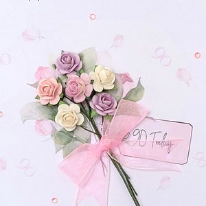 May include: A white card with the text "Happy 90th Birthday" and a bouquet of pink, white, and purple paper flowers tied with a pink ribbon. The card also has a tag that says "90 Today".