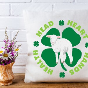 May include: White throw pillow with a green shamrock design and the text "Head, Heart, Hands, Health" around the shamrock. A white lamb is standing in the center of the shamrock.