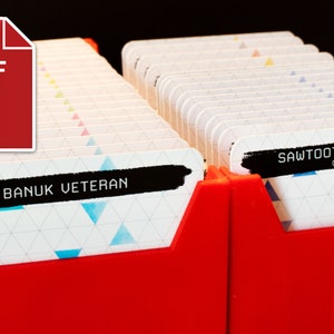 Peut inclure: Un porte-cartes en plastique rouge avec une carte blanche qui dit "Sawtooth Hunt Deck Core Game" et une autre carte blanche qui dit "Banuk Veteran".