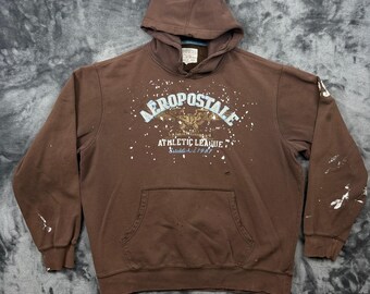 Sudadera con capucha Aeropostale para hombre, talla XL, color marrón claro, con estampado de salpicaduras de pintura desgastadas.