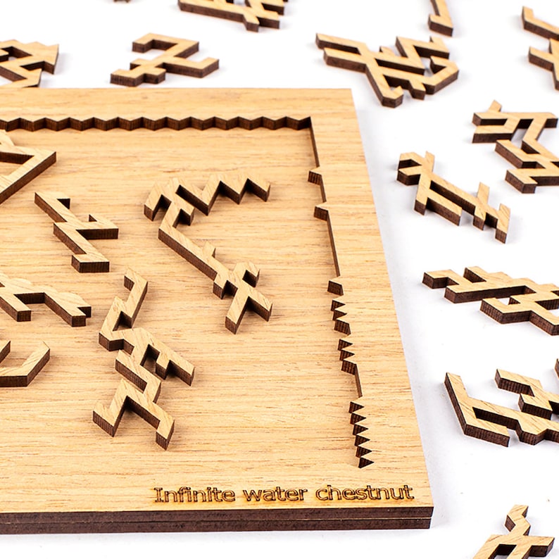 Puede incluir: Un rompecabezas de madera con un acabado marr&oacute;n claro. Las piezas del rompecabezas est&aacute;n dispersas alrededor de un marco de madera con las palabras "Infinite water chestnut" grabadas en la parte inferior. Las piezas del rompecabezas son formas geom&eacute;tricas.