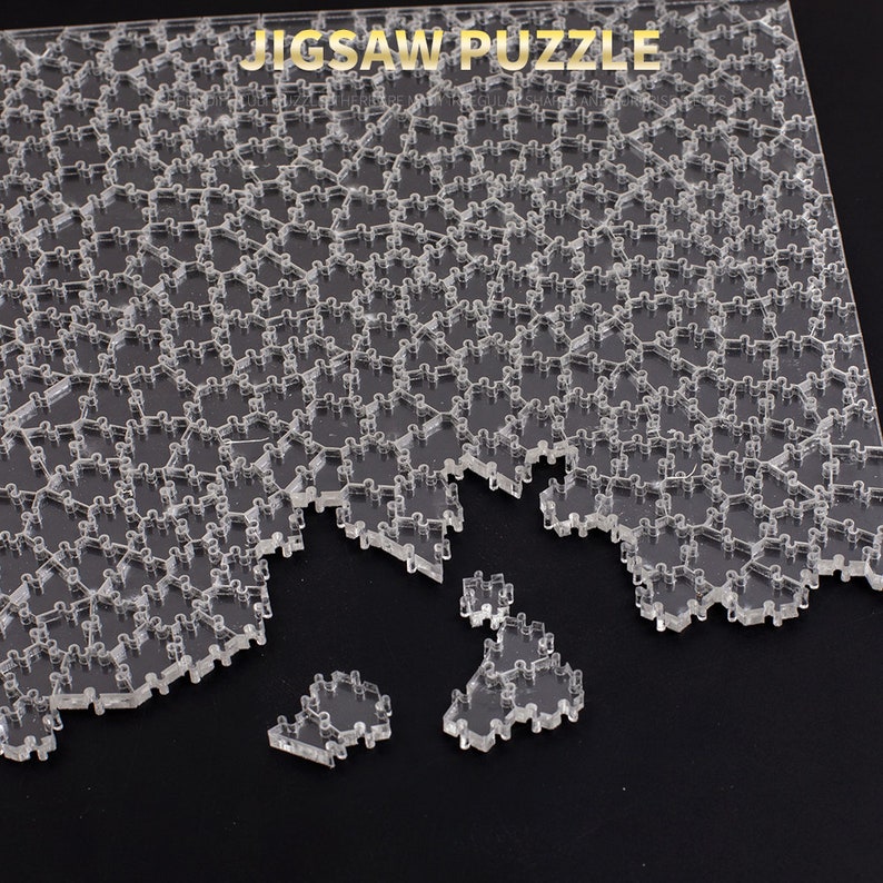 Puede incluir: Un rompecabezas de acr&iacute;lico transparente con piezas entrelazadas, parcialmente ensamblado. Las palabras "JIGSAW PUZZLE" est&aacute;n impresas en la parte superior. Varias piezas est&aacute;n separadas, mostrando el dise&ntilde;o del rompecabezas.