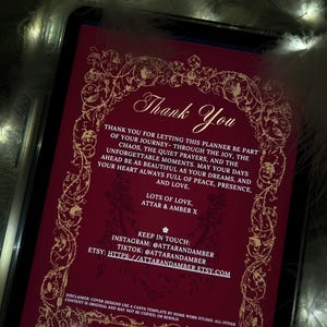 Puede incluir: Un planificador digital que se muestra en la pantalla de una tableta. El planificador tiene un fondo rojo oscuro con bordes dorados ornamentados con motivos florales y volutas. El texto "Thank You" est&aacute; en la parte superior, con texto adicional debajo.