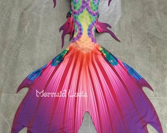 May include: A mermaid tail fin with a colorful, patterned design. The fin is made of fabric and has a purple, pink, and orange color scheme. The fin is designed to be worn for swimming or as a costume.