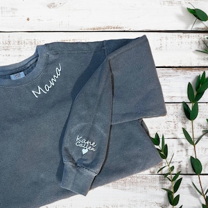 May include: A gray sweatshirt with the word "Mama" embroidered on the front and "Kane Callen" with a heart embroidered on the left sleeve.