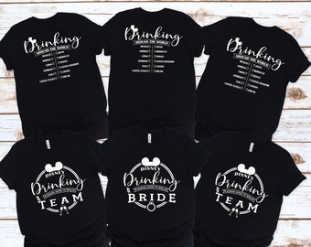May include: Three black t-shirts with white text and graphics. The shirts have the text "Drinking Around the World" and a Mickey Mouse head. The shirts also have the text "Disney Drinking Team", "Disney Drinking Bride", and "Disney Drinking Team".
