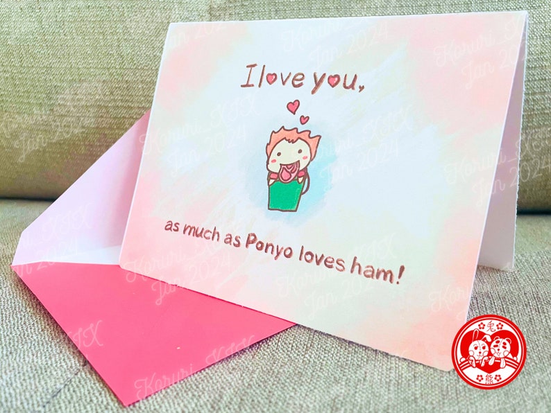 Puede incluir: Una tarjeta rosa y blanca con un personaje de dibujos animados sosteniendo una flor roja. La tarjeta dice "Te quiero, tanto como Ponyo ama el jam&oacute;n!" con un sello de coraz&oacute;n rojo en la esquina inferior derecha.