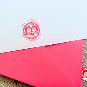 Puede incluir: Un sello rojo y blanco con un coraz&oacute;n y dos animales de dibujos animados. El sello dice "Made with love by Bunnies from Bunny x Bear 23".