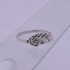 May include: Silver ring with a detailed wing design.