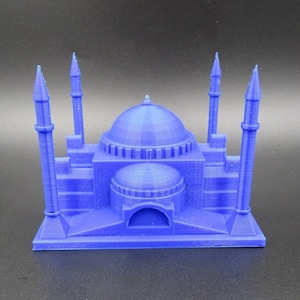 May include: A blue 3D printed model of a mosque with six minarets and a domed roof.