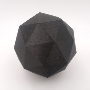Può includere: Una sfera geometrica nera stampata in 3D con una superficie testurizzata.