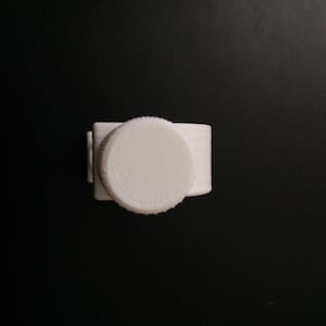 May include: White plastic bottle cap with a textured surface.