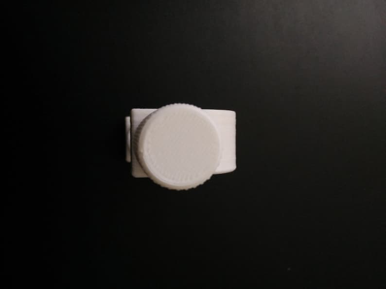 May include: White plastic bottle cap with a textured surface.