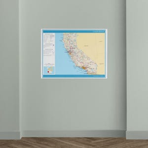 May include: A framed map of California, featuring detailed road networks, cities, and geographical features. The map has a blue border and includes a legend with symbols. The state's coastline is visible, with the Pacific Ocean in blue.