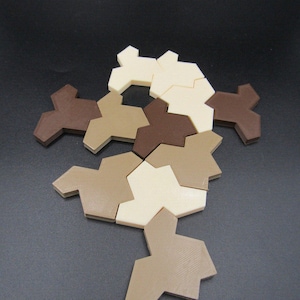 May include: A geometric puzzle made of 10 pieces in three colours: brown, tan, and cream. The pieces are arranged in a curved shape.