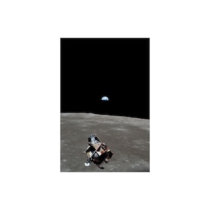 Op de afbeelding: Een zwart-witfoto van een maanlander op het oppervlak van de maan met de aarde in de verte.