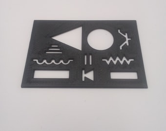 May include: A black plastic stencil with various shapes and symbols, including a triangle, circle, wavy lines, and a rectangle.