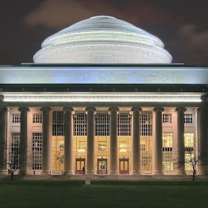 May include: A night view of the Massachusetts Institute of Technology (MIT) building with a large dome and columns. The building is lit up and the dome has the year MCMXVI inscribed on it.