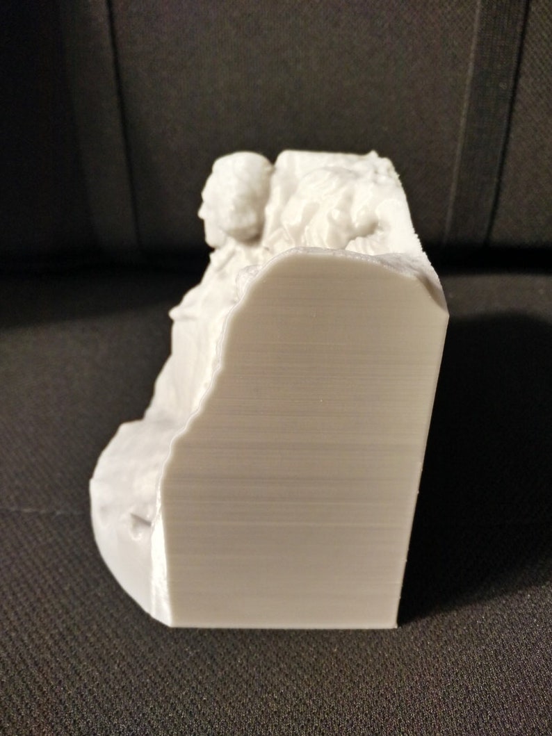 Pu&ograve; includere: Scultura in 3D stampata in bianco di un gruppo di persone sedute insieme. La scultura &egrave; dettagliata e ha una finitura liscia e opaca.