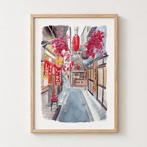 May include: A framed watercolor painting of a narrow Japanese alleyway featuring red paper lanterns, vibrant pink maple leaves, and red banners with Japanese text hanging from wooden structures. A small red stool sits on the pavement.