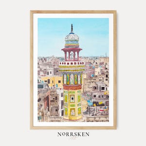 Puede incluir: Una pintura de acuarela en un marco de madera clara que representa un minarete alto y ornamentado con paneles decorativos amarillos, verdes y rojos sobre un denso paisaje urbano de edificios beige bajo un cielo azul claro. El texto NORRSKEN Art está debajo.
