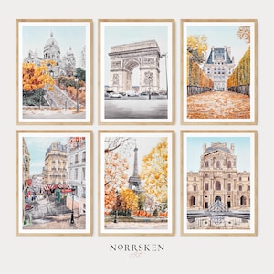 K&ouml;nnte beinhalten: Sechs gerahmte Aquarelldrucke mit ikonischen Pariser Wahrzeichen. Die Kunstwerke zeigen unter anderem die Basilika Sacr&eacute;-C&oelig;ur, den Arc de Triomphe und den Eiffelturm mit herbstlichem Laub. Die Rahmen sind helles Holz, das Thema ist Reisen und Kunst.