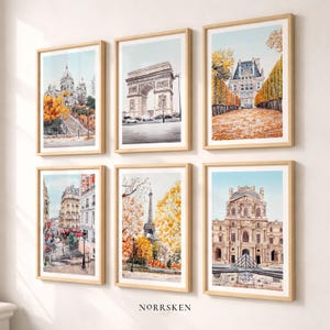 K&ouml;nnte beinhalten: Sechs gerahmte Aquarelldrucke von Pariser Wahrzeichen, darunter der Eiffelturm und der Arc de Triomphe. Die Kunstwerke zeigen Herbstfarben und sind in hellen Holzrahmen gefasst, was eine warme, einladende &Auml;sthetik erzeugt.