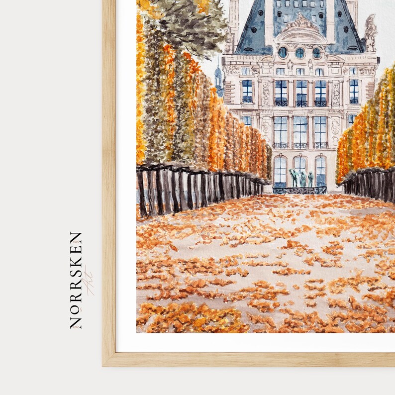 K&ouml;nnte beinhalten: Aquarelldruck eines europ&auml;ischen Geb&auml;udes mit blauem Dach und vielen Fenstern. Das Kunstwerk zeigt einen Weg, der von B&auml;umen und Herbstlaub ges&auml;umt ist, in einem Holzrahmen. Der Name des K&uuml;nstlers, NORRSKEN, ist links aufgedruckt.