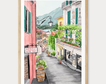 Könnte beinhalten: Aquarelldruck einer italienischen Straßenszene mit einem Weinbarschild. Das Kunstwerk zeigt eine Kopfsteinpflasterstraße, Gebäude mit grünen Fensterläden und einen Berg im Hintergrund. Das Schild lautet "APERITIVI WINE BAR".