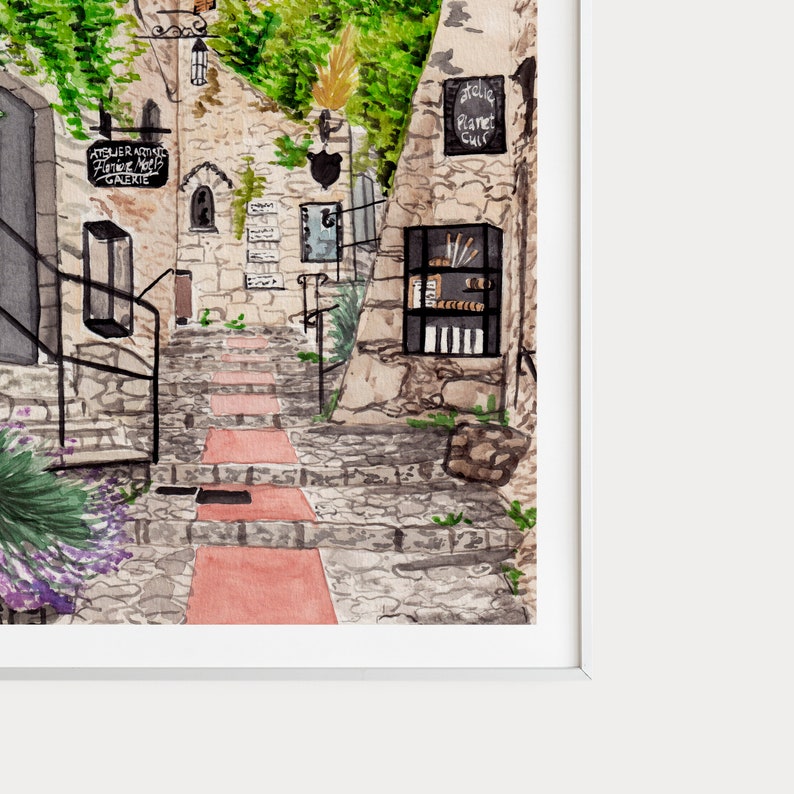May include: Watercolor painting of a stone pathway leading up a set of stairs in a European village. The buildings are made of stone and have windows and doors. There are plants growing on the walls and in the street. The painting is in a white frame.