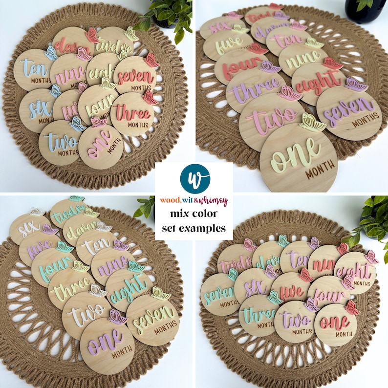 May include: A set of 12 wooden baby milestone discs with pastel pink, yellow, and green butterflies. The discs are numbered one through twelve and have the word "month" written on each disc. The discs are arranged in a circle on a woven mat.