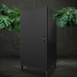 Könnte beinhalten: Ein schwarzer Metallschrank mit einer einzigen Tür und einem Schloss. Der Schrank steht auf vier Beinen und hat eine strukturierte Oberfläche. Der Text "QUANTUM PRO BLACK" ist auf der Oberseite des Schranks aufgedruckt.