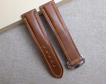 Può includere: Due cinturini per orologio in pelle marrone con cuciture a contrasto. Un cinturino ha più fori per la regolazione, e l'altro ha una chiusura color argento. I cinturini sono realizzati in pelle liscia di alta qualità.