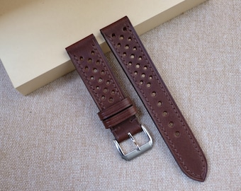 Puede incluir: Dos correas de reloj de cuero marrón con un patrón perforado. Las correas tienen una hebilla plateada.